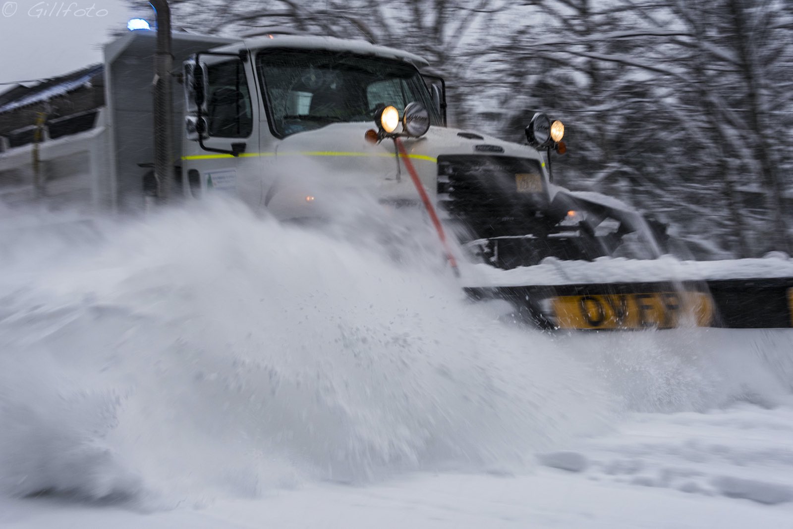 Plow blade throwing a wave of fresh snow