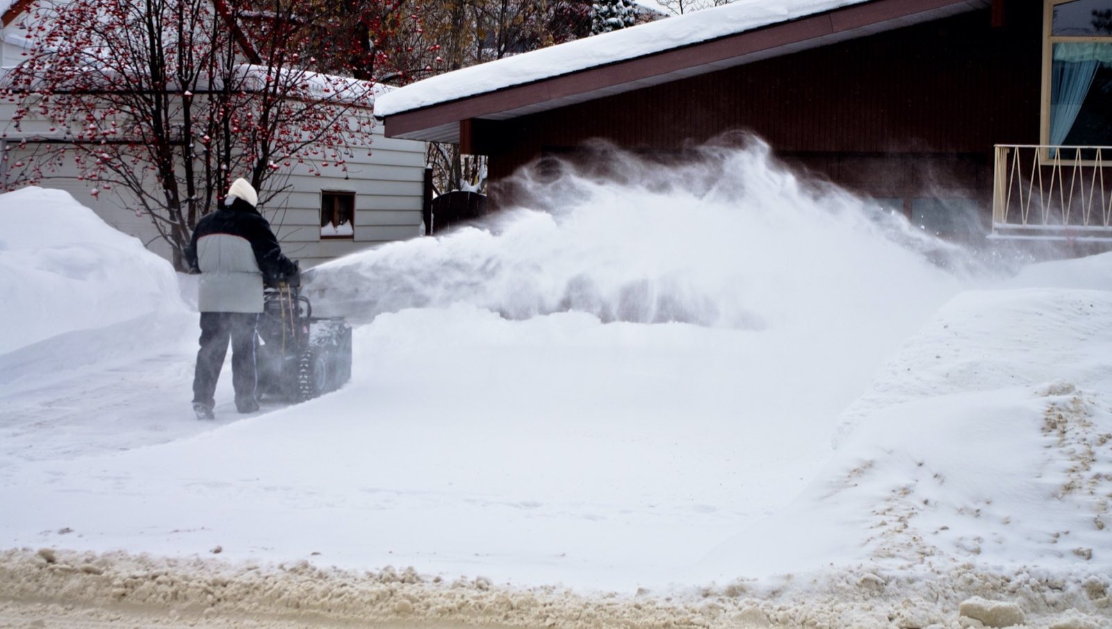 Snowblower clearing a residential driveway