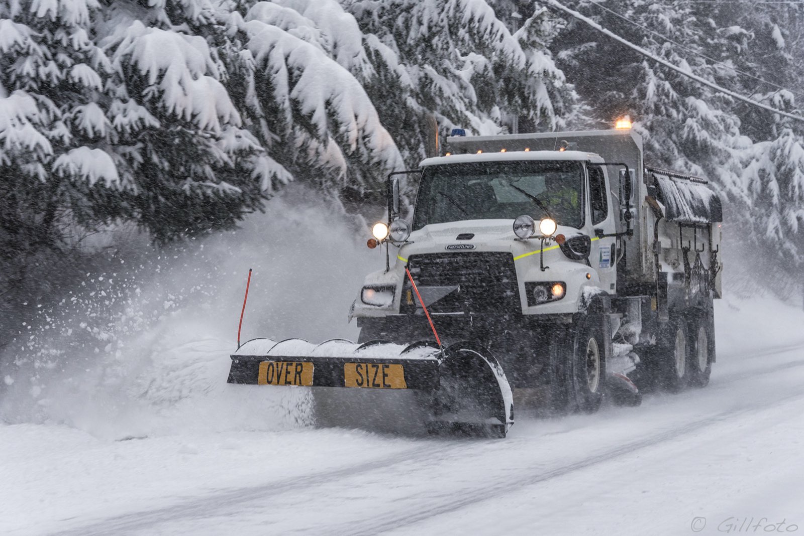 Plow truck clearing a residential street in morning light